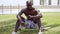 Handsome shirtless black man seated on skateboard