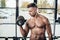 handsome shirtless muscular sportsman training with dumbbell