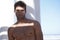 Handsome, shirtless and portrait of man outdoor by pillars at beach with confidence on vacation. Serious, model and