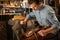 Handsome shoemaker sitting in workshop making shoes