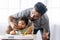 Handsome single young father feeding spaghetti for his mixed race daughter while baby girl sitting on high chair. Infant cute