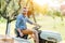 handsome smiling gardener, man trimming grass in garden using tractor