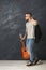 Handsome smiling man with guitar posing in studio