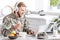 handsome soldier in headphones using laptop at kitchen table while