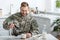 Handsome soldier in uniform smiling and pouring coffee in cup