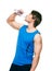Handsome sportsman in blue shirt drinks water.