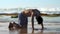 Handsome sportsman practices yoga near endless ocean