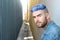 Handsome stylish young man with artificially coloured blue dyed hair undercut hairstyle, beard and piercings with copy space