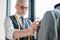 handsome tailor touching jacket on mannequin