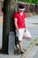 Handsome teenage boy with skateboard standing on street