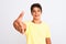 Handsome teenager boy standing over white isolated background smiling friendly offering handshake as greeting and welcoming