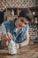 handsome teenager putting dollar banknotes into saving glass jar