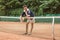 handsome tennis player with racket leaning on tennis net