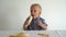 Handsome toddler is eating yellow banana. Gimbal motion shot