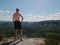 Handsome topless hiker looking at horizon with high Sun