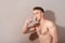 Handsome topless man drinking water