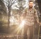 Handsome traveler with hiking poles in autumnal forest