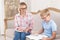 Handsome tutor and her young pupil doing English homework. Little boy translating text in his textbook while tutor