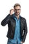 Handsome unshaved man in leather jacket fixing eyeglasses