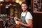 Handsome waiter adding milk to coffee