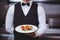 Handsome waiter holding a plate