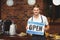 Handsome waiter presenting open sign