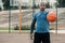 Handsome well built man standing on the basketball court