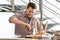 Handsome working man repairing wooden stool at table