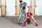 Handsome yoga male personal trainer with a beard helping young fitness girl to stretch her muscles after hard training workout, re