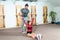 Handsome yoga male personal trainer with a beard helping young fitness girl to stretch her muscles after hard training workout, re