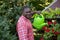 Handsome youg man watering red geraniums outdoors