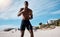 A handsome young african american male athlete working out on the beach. Dedicated black man shadow boxing while