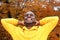 Handsome young african american man against autumn leaves in background smiling with hands behind head