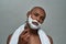 Handsome young african american man with shaving foam applied on his face looking at camera, holding steel razor, posing