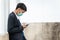 A handsome young asian business man using smartphone. Asian young attractive businessman wearing a face mask leaning against the