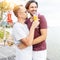 Handsome young attractive male couple, gay couple and family, Valentine`s Day at a tropical resort with cocktails in their hands