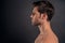 Handsome young bearded man isolated. Portrait of shirtless muscular man is standing on grey background. Men care concept