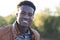 Handsome young black man smiling with defocused trees in the background