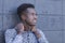 Handsome young black man stands in front of gray block wall