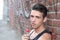 Handsome young brunette man with a lollipop, against urban graffiti background