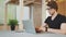 Handsome young businessman working in loft office. A focused young man with glasses turns on his laptop and starts typing.