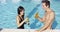 Handsome young couple toasts in swimming pool
