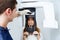 Handsome young dentist taking dental x-ray of woman in the dental clinic