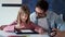 Handsome young father with his daughter drawing with digital tablet at home