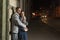 Handsome young guy hugs his girlfriend on night city background. Young couple on evening romantic date