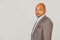 Handsome young male African American businessman in jacket looking at the camera holding his head in three quarters with