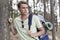 Handsome young man with backpack hiking in forest