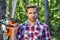 Handsome young man with a beard carries a tree. Woodworkers lumberjack. Firewood as a renewable energy source