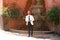 Handsome young man with beard and white jacket is in the mudejar quarter of seville. In the background the famous fountain of the