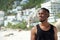 Handsome young man in black shirt standing at the beach